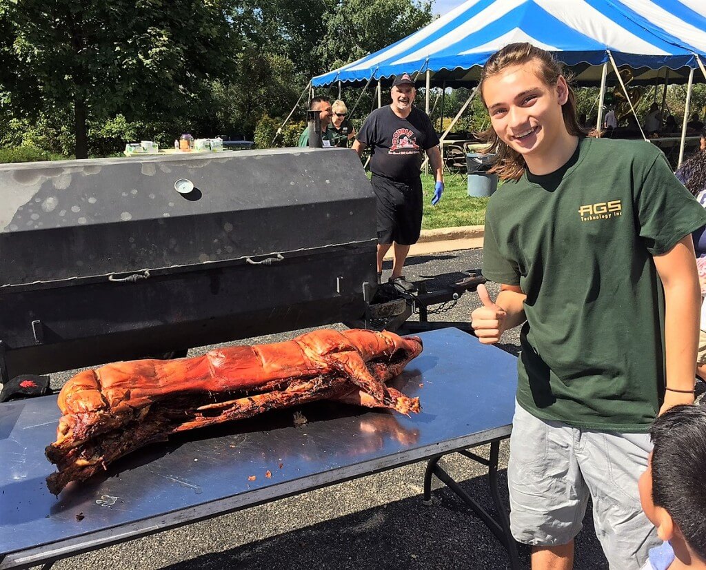 Cameron give a thumbs up to the pig roast.